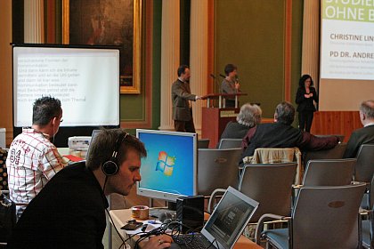 Ein Schriftdolmetscher (links) fertigt eine Livemitschrift der Redebeitrge an, Ulrich Peinhardt (2.v.l.) bedient den Livestream fr das Internet, die Gebrdensprachdolmetscherin Heike Leps (Mitte hinten) dolmetscht in DGS