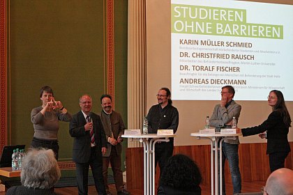 In einer Podiumsdiskussion sprechen Andreas Diekmann (Haupt-Schwerbehindertenvertrauensperson beim Ministerium fr Wissenschaft und Wirtschaft des Landes Sachsen-Anhalt, links), Dr. Andreas Weber (FST, 2.v.l.), Dr. Christfried Rausch (Mitarbeiter des Behindertenbeauftragten des akademischen Senats der Universitt, Mitte), Dr. Toralf Fischer (Beauftragter fr die Belange der Menschen mit Behinderung der Stadt Halle, 2.v.r.) sowie Karin Mller Schmied (Bundesarbeitsgemeinschaft Hrbehinderter Studenten und Absolventen, rechts) ber Vernetzungsmglichkeiten beim Abbau von Studienbarrieren zwischen Universitt, Stadt und Land (Gebrdensprachdolmetscherin: Heike Leps)